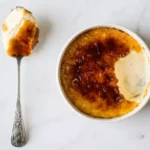 A spoon with a bowl of creme brulee, a quick single serving dessert.