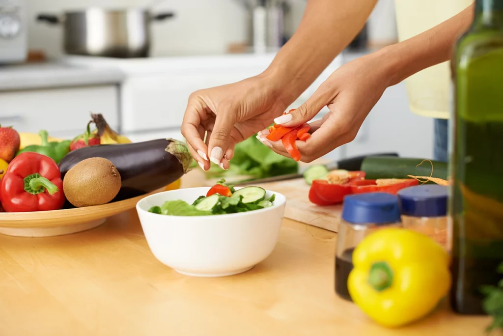 a woman preparing a salad in a bowl