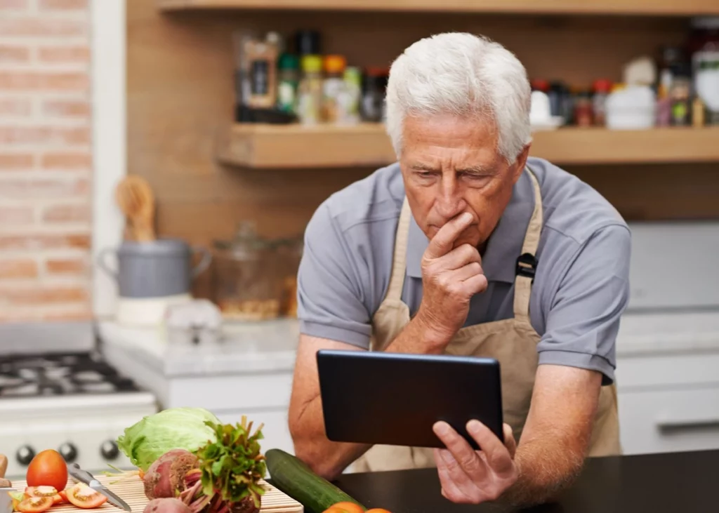 A man looking at a recipe figuring out how to scale down a recipe for one serving