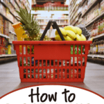 A red shopping basket filled with groceries sits on the floor of a supermarket aisle, perfectly capturing the art of grocery shopping for one. Text reads: “How to grocery shop for one.”.