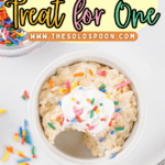 A single serving Rice Krispie treat in a white ramekin, topped with whipped cream and rainbow sprinkles, with a spoonful taken out and sprinkles scattered nearby—perfectly portioned as a Rice Krispie treat for one.